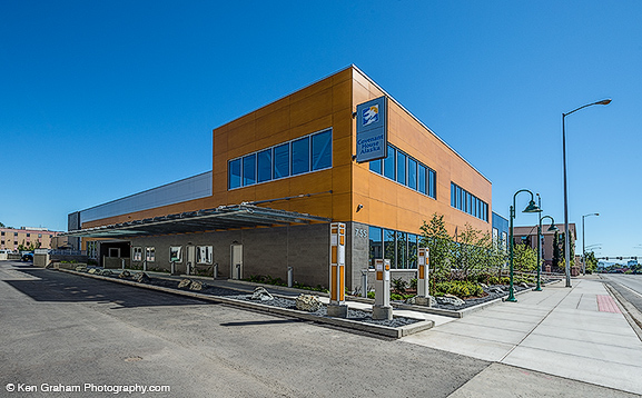 Modern exterior of the Fairbanks Community Museum building with orange paneling and large windows on a clear day