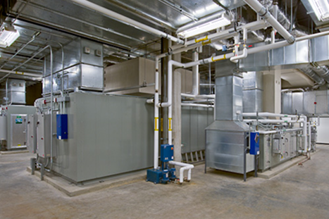 Industrial mechanical room with HVAC units, ductwork, and piping systems