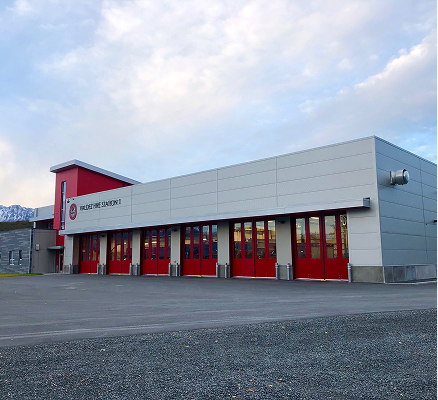Valdez Fire Station 1 building with white exterior and row of red garage doors