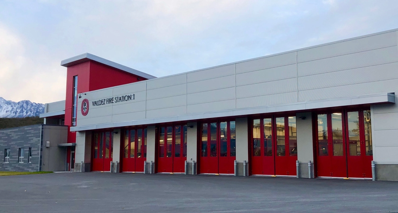 Valdez Fire Station 1 building with white exterior and multiple red garage doors